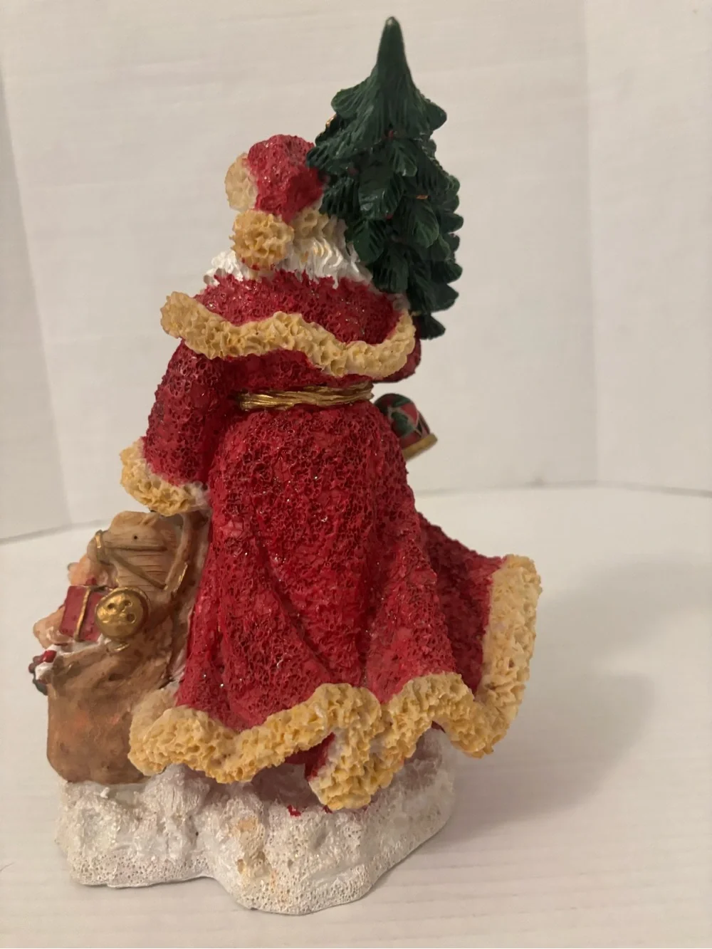 Festive Red Santa Figurine with Green Tree and Brown Toy Sack